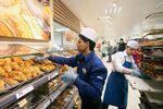 Employees replenishes bread stocks in the bakery at a Tesco Metro store in London