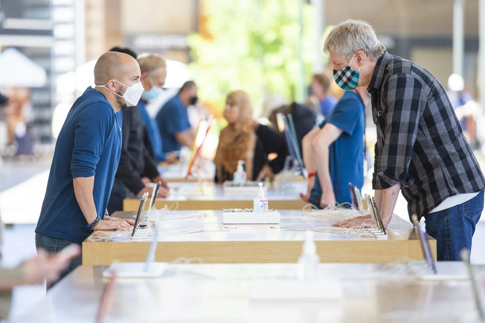 An employee helps a customer at an Apple store in Palo Alto, California.