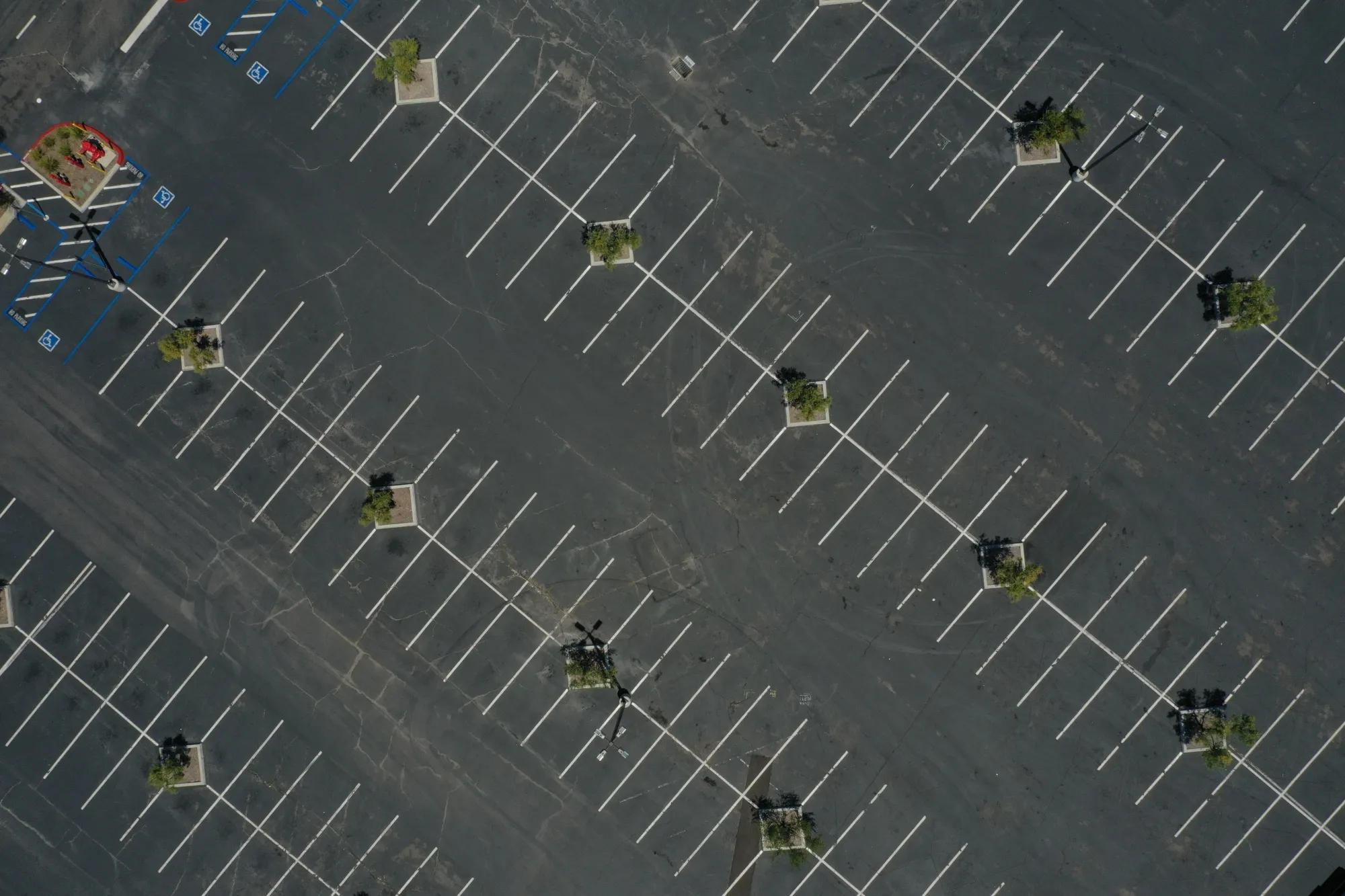 An empty parking lot is seen at a shopping complex in this aerial photograph taken over San Diego, California, U.S. on Thursday, May 7, 2020. Emptied out malls and hotels across the U.S. have triggered an unprecedented surge in requests for payment relief on commercial mortgage-backed securities, an early sign of a pandemic-induced real estate crisis.