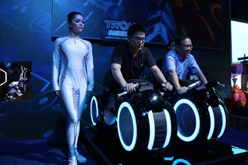 A staff member stands next to visitors at the unveiling of six themed parks of Shanghai Disney Resort in July 2015.