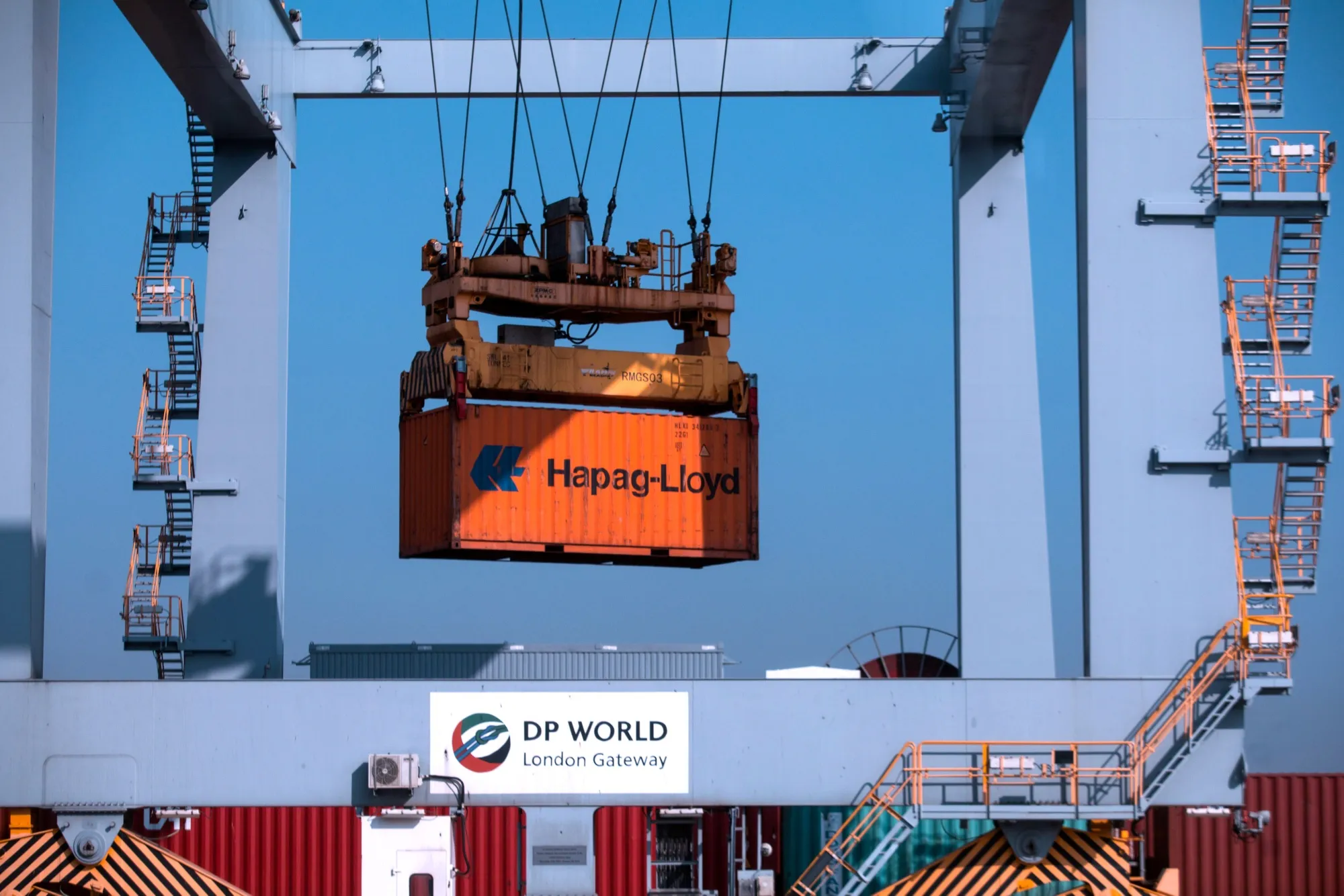 A crane carries a&nbsp;Hapag-Lloyd container at London Gateway port.