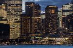 The Overseas Passenger Terminal, foreground right, and buildings in the financial district stand illuminated at dusk in Sydney, Australia, on Friday, Sept. 29, 2017. A bungled transition from coal to clean energy has left resource-rich Australia with an unwanted crown: the highest power prices in the world. Photographer: Cole Bennetts/Bloomberg