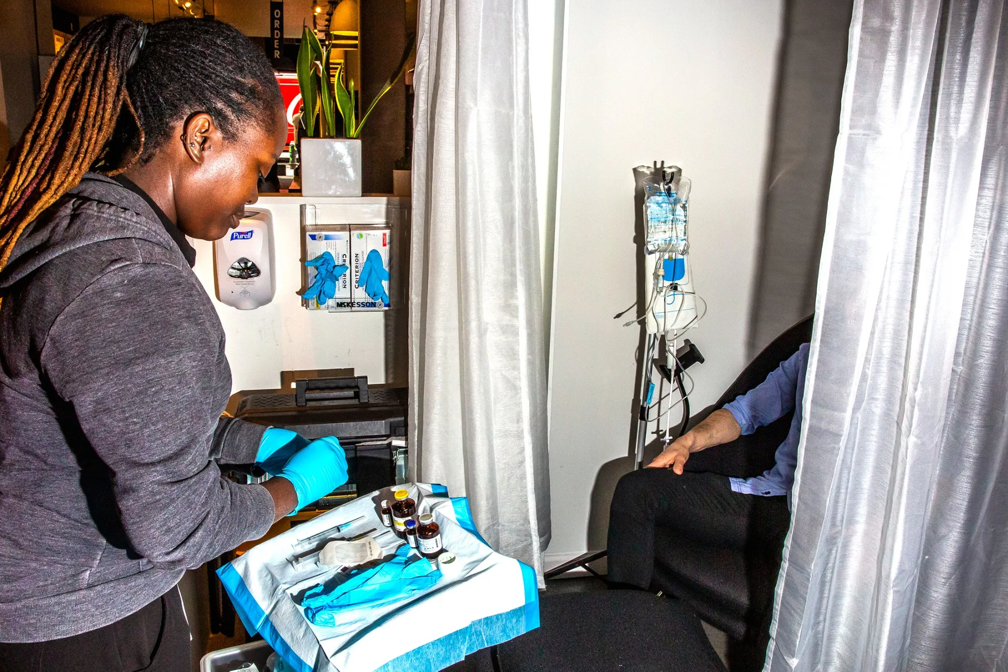 A nurse assists a patient with a treatment from the I.V. Doc, an on-demand luxury service that offers intravenous treatments, at the company’s lounge in New York. 