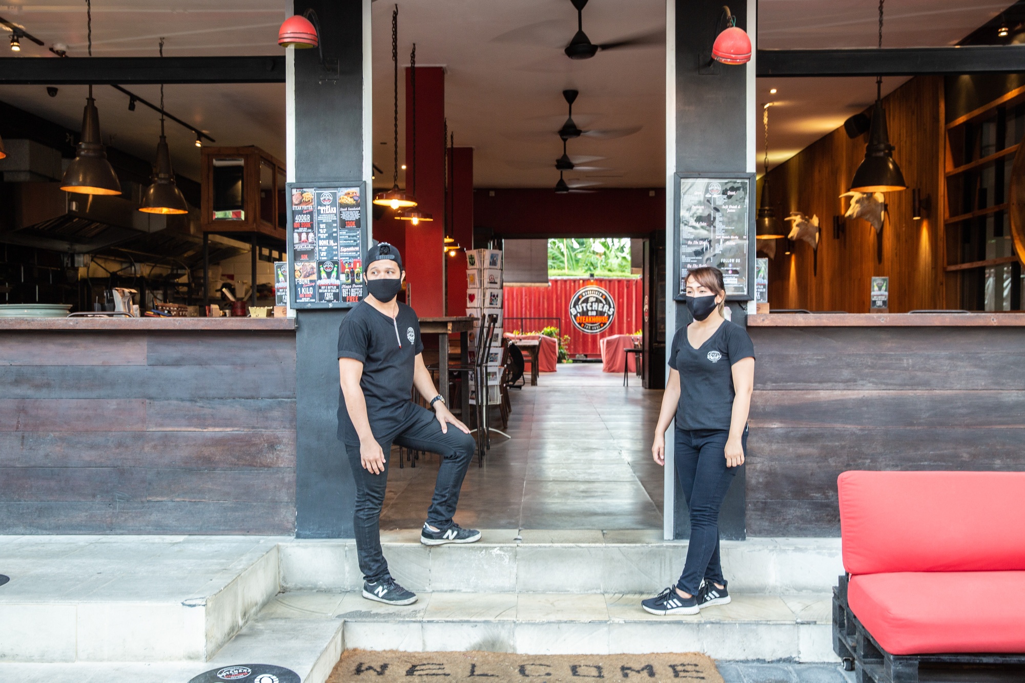 Employees stand outside a restaurant as they wait for customers in Seminyak, Bali.