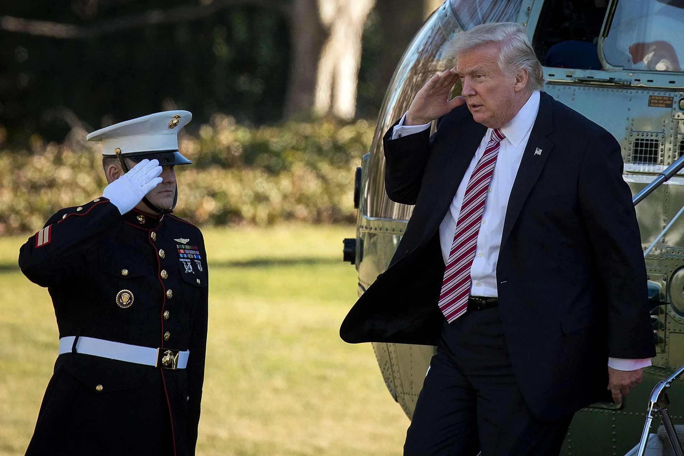 President Donald Trump salutes as he exits Marine One at the White House, Jan. 26.
