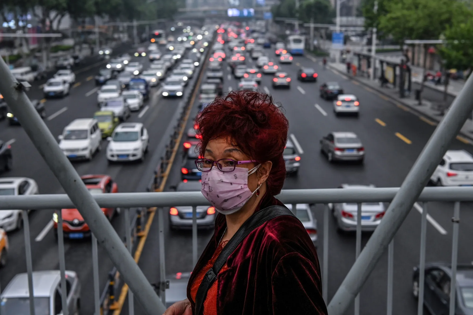 A woman walks on a pedestrian bridge in Wuhan, May 14.