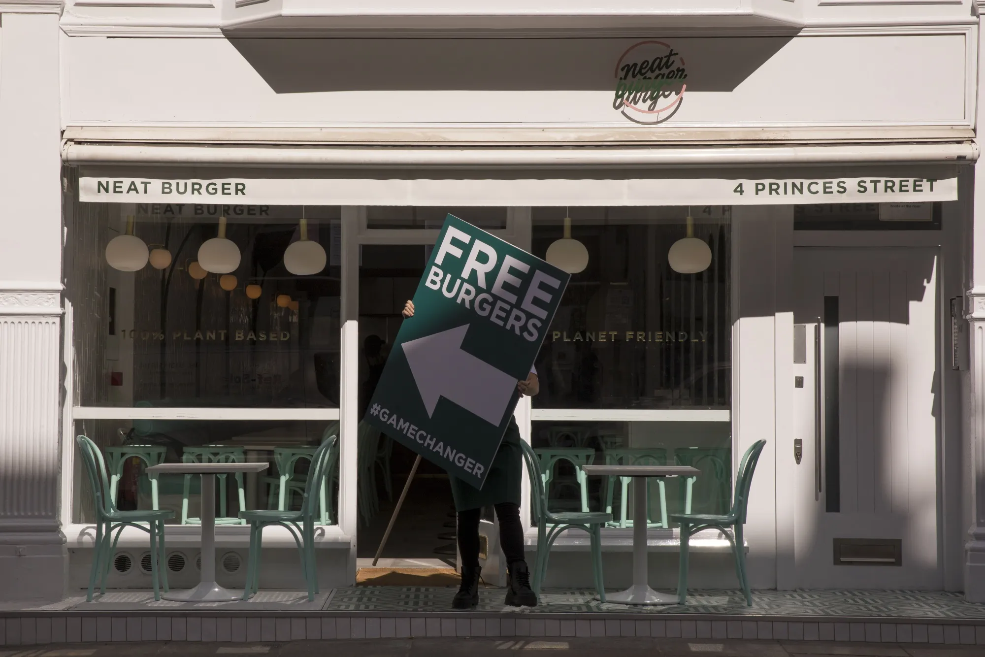 A employee carries a sign offering free burgers during the launch of the meat-free Neat Burger fast-food joint in London on Sept. 2.