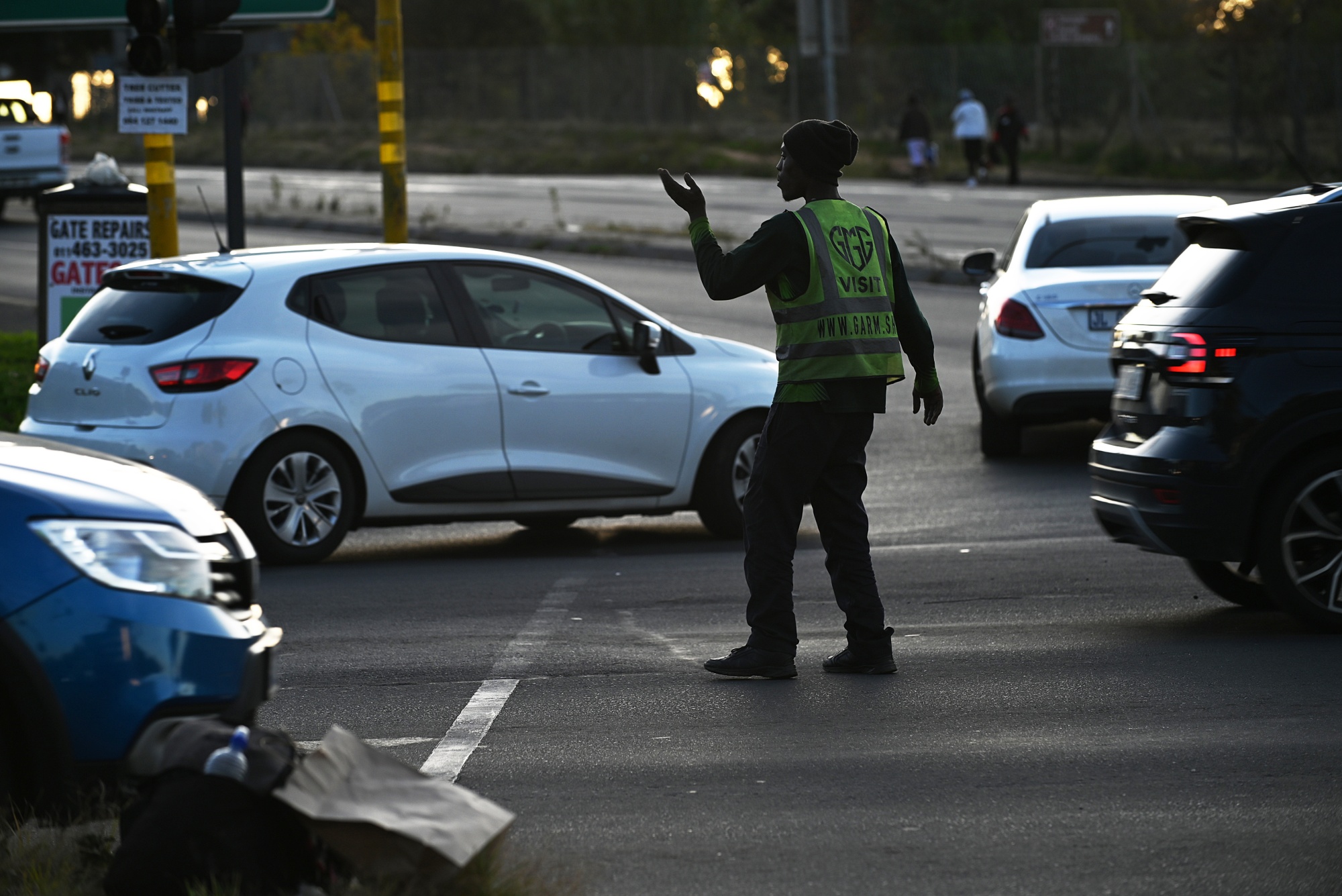 A self-appointed traffic controller directs traffic, to make money from driver tips, while traffic lights are down during a power shutdown, known locally as loadshedding, in Johannesburg, South Africa, on Tuesday, May 23, 2023. Africa's richest city was built on gold, but it’s now defined by chaos, crime and corruption more than ever and encapsulates the wider collapse of basic services across South Africa. Photographer: Leon Sadiki/Bloomberg