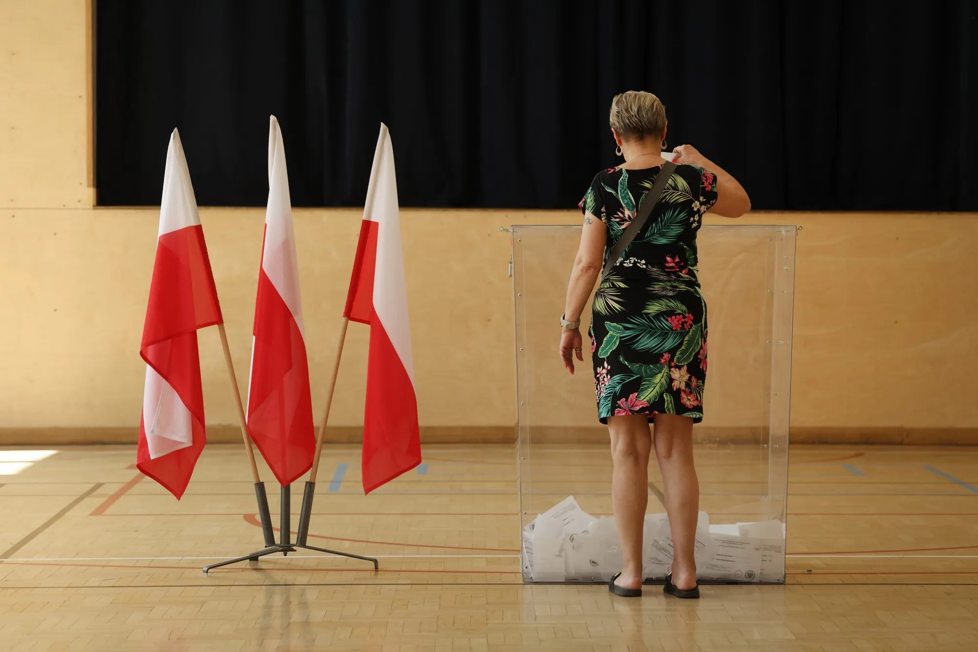 A voter casts her ballot at a polling station during the Polish presidential runoff election in Warsaw on June 1