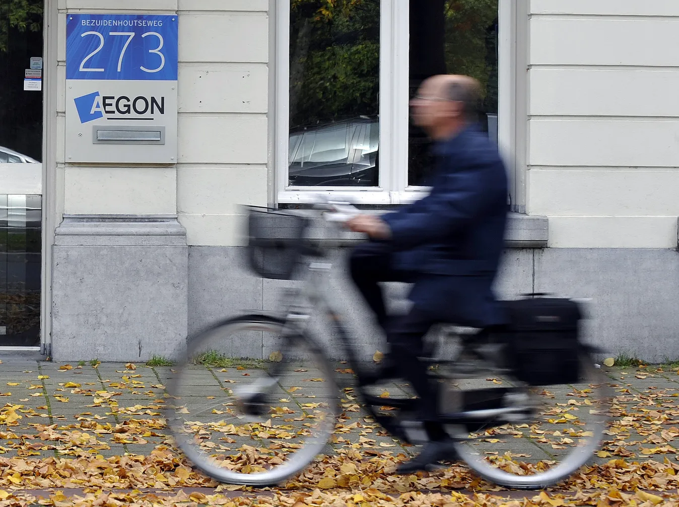 A cyclist passes the Aegon NV headquarters in the Hague.