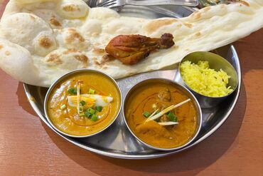 Indian Thali Platter with Curries, Naan, Rice, and Tandoori Chicken