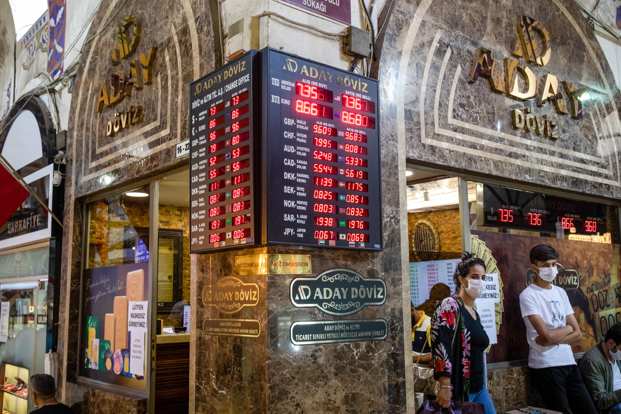 Customers wearing protective face masks exit a Bureau de Change currency and gold exchange shop in the Grand Bazaar, in Istanbul.