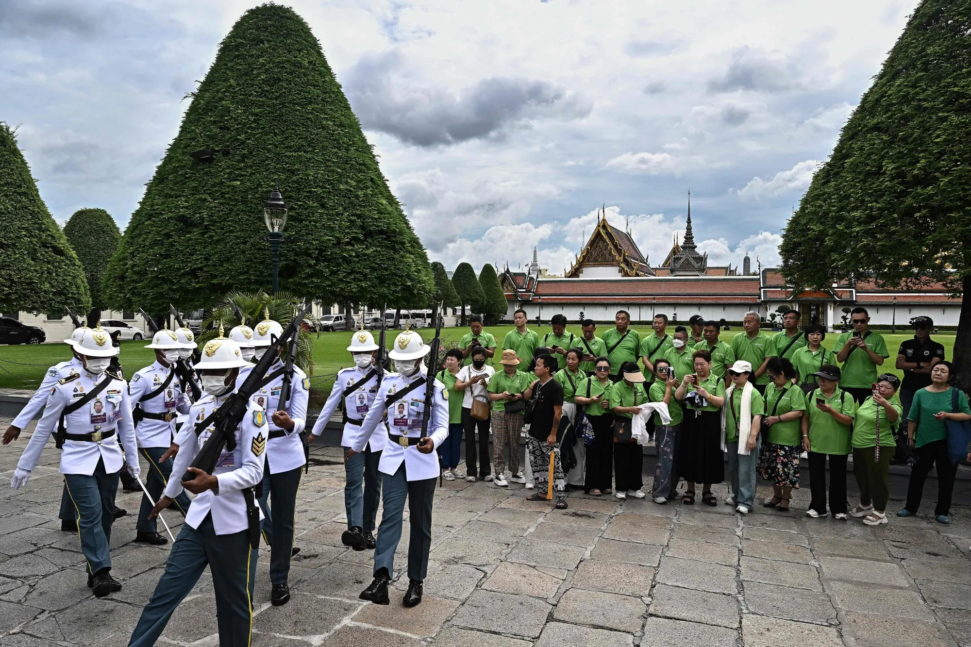 Chinese tourists watch a changing of the guards at the Grand Palace in Bangkok.