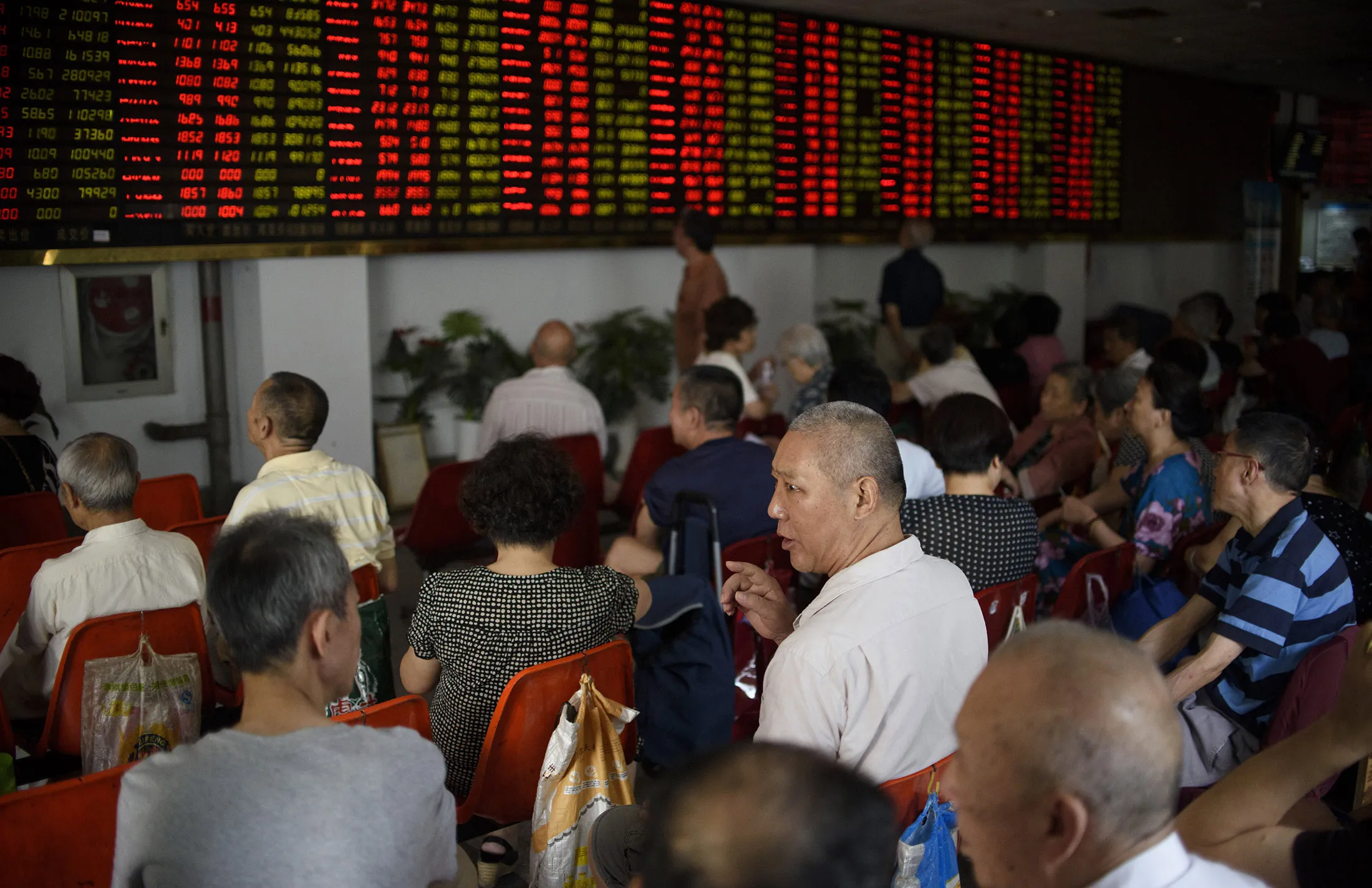 Investors monitor screens showing stock market movements at a brokerage house in Shanghai on July 29.
