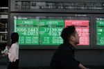 An electronic stock board displays the Shanghai Composite Index, the Nikkei 225 Stock Average and the Dow Jones Industrial Average outside a securities firm in Tokyo, in Tokyo, Japan, on April 19, 2024. The Nikkei had its biggest weekly drop since June 2022 amid a global selloff in stocks as the outlook for US interest rates and tensions in the Middle East spooked investors. Photographer: Soichiro Koriyama/Bloomberg