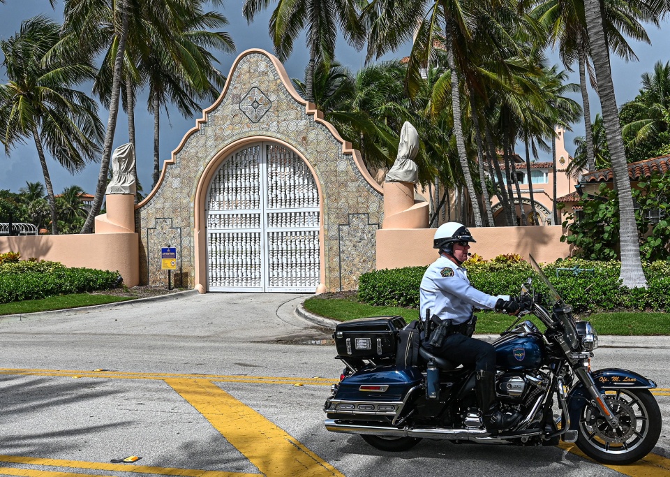 A police officer rides past Mar-A-Lago, the home of former President Donald Trump, in Palm Beach, Florida on Aug. 9.