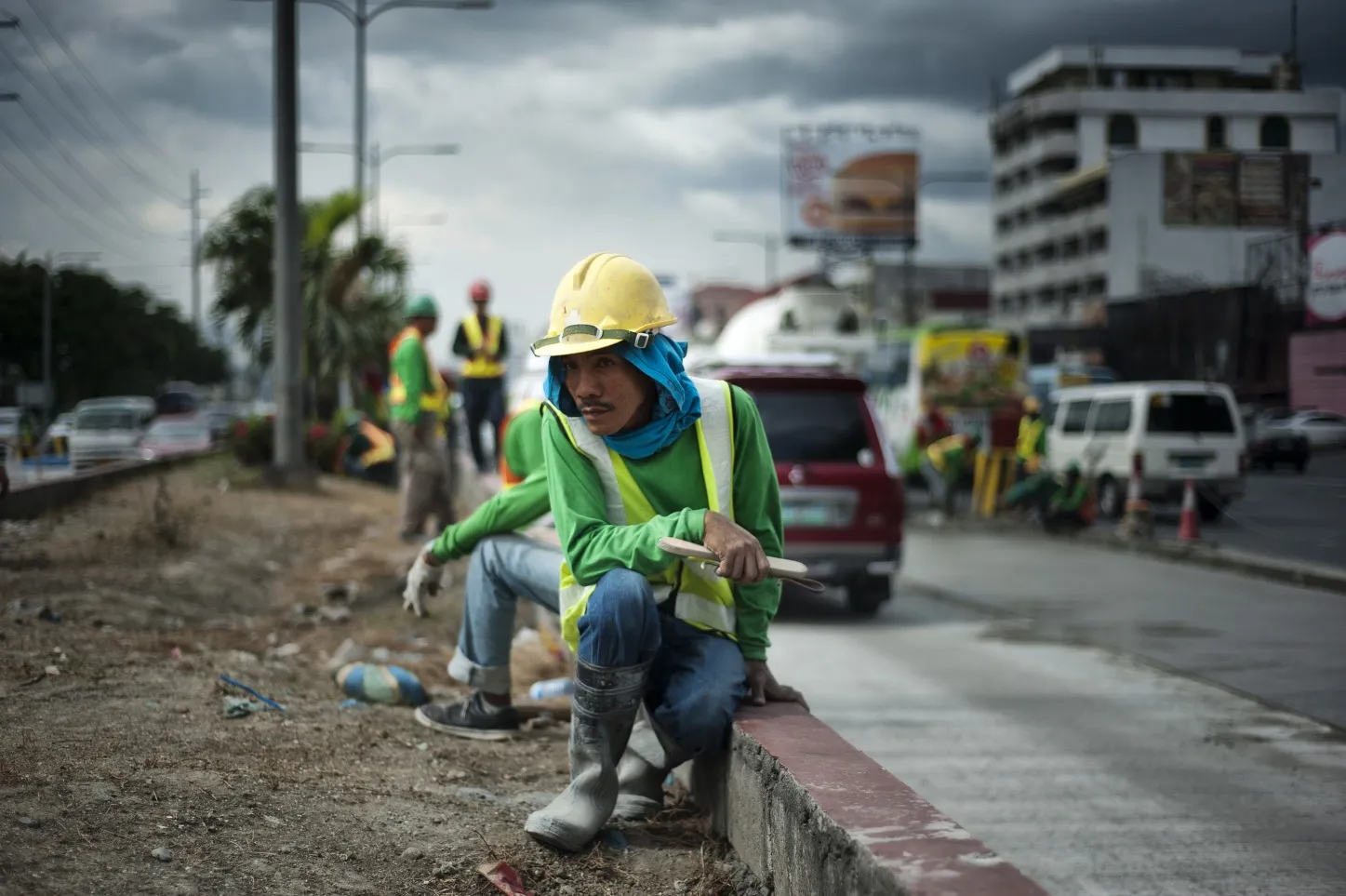 Workers lay concrete on a road in Manila.