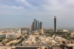 The headquarters of the Abu Dhabi National Oil Co., right, and Etihad Towers, center, surrounded by residential and commercial properties in Abu Dhabi, United Arab Emirates.
