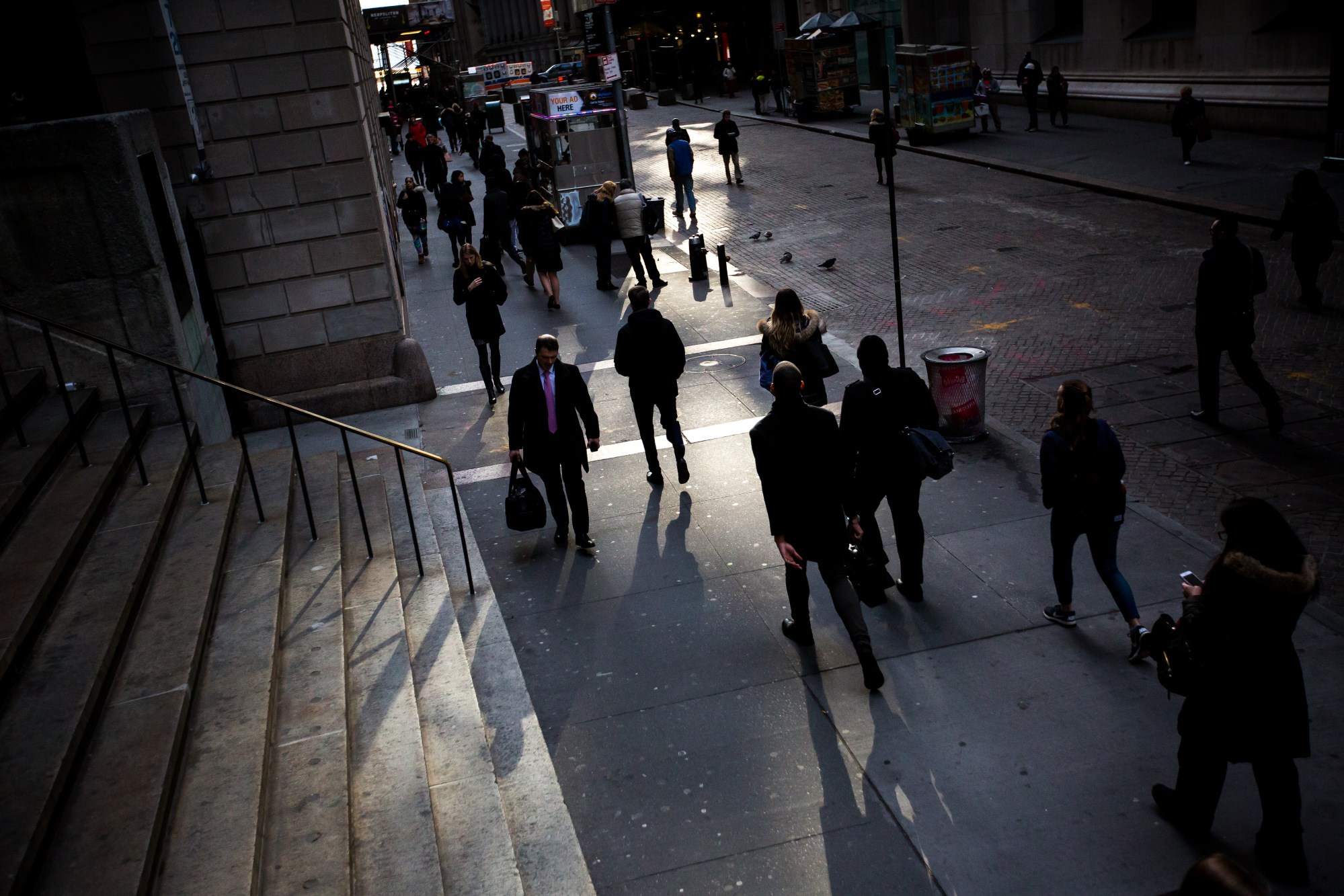 Pedestrians walk along Wall Street near the New York Stock Exchange (NYSE) in New York, U.S., on Monday, March 12, 2018.&nbsp;