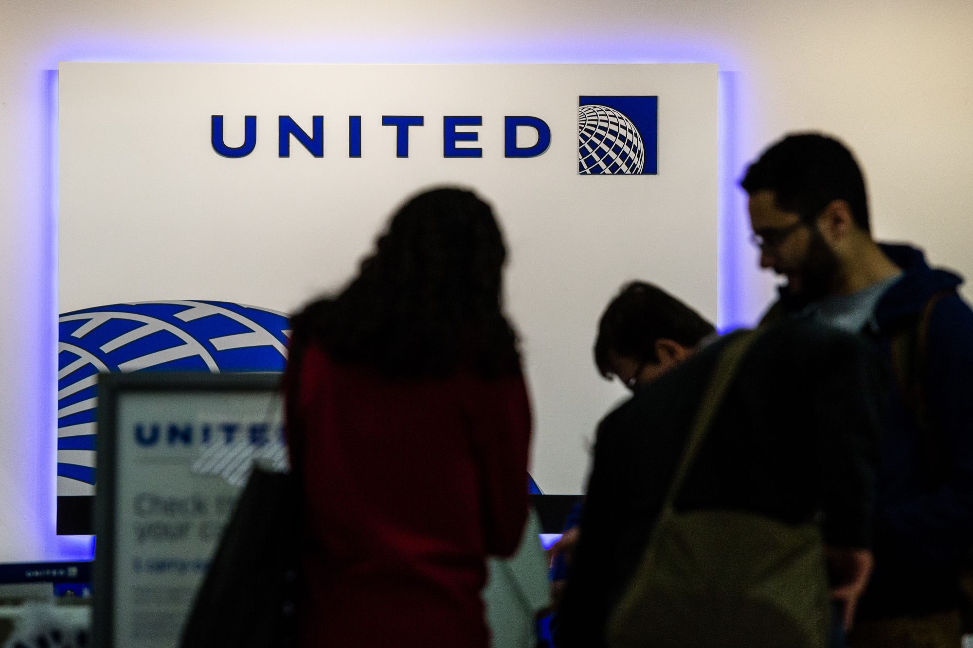 Passengers use self check-in kiosks inside the United Continental Holdings Inc. terminal.