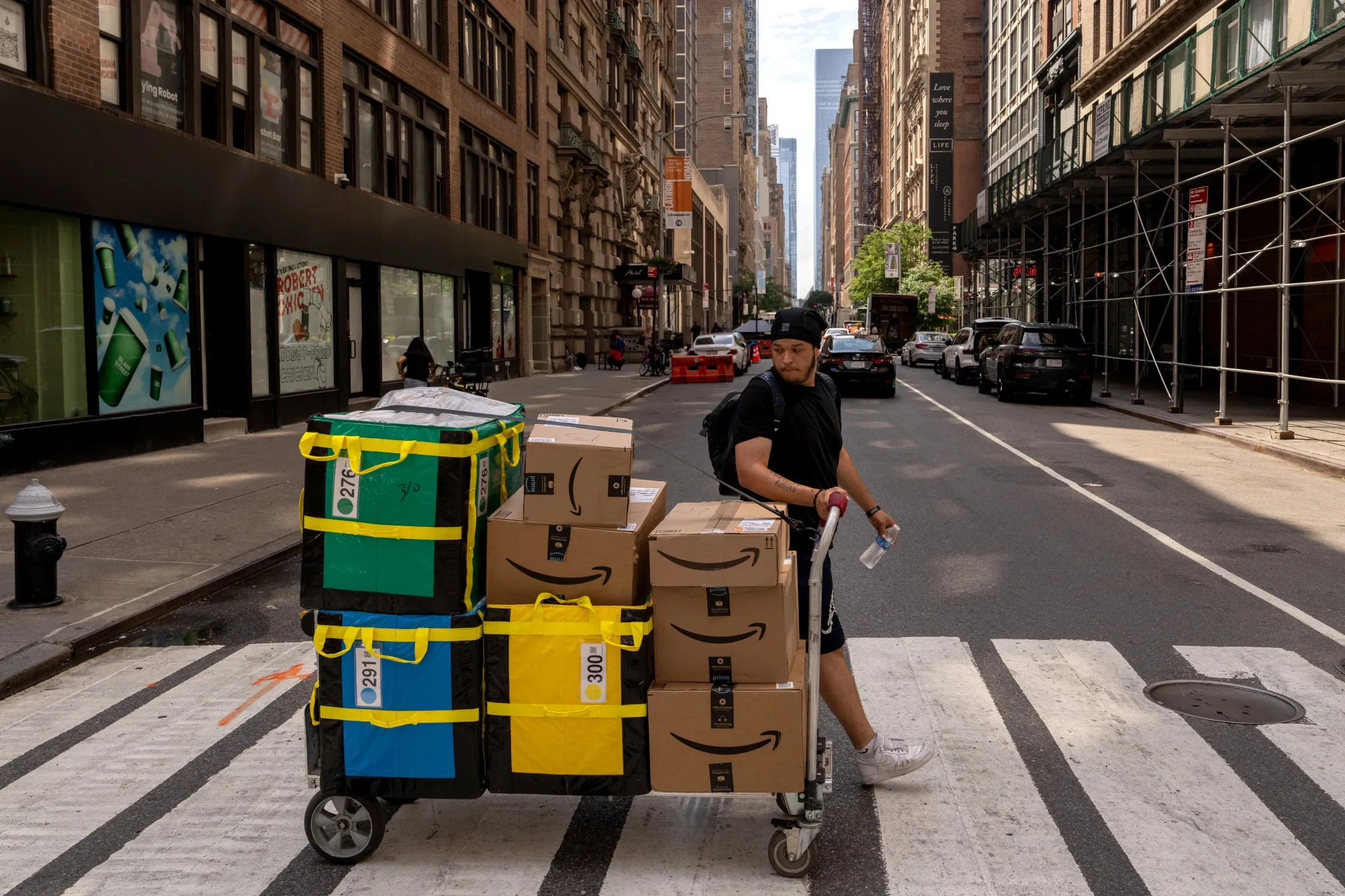 A delivery worker moves Amazon packages in New York.