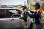 A motorist is cleared to proceed by an officer with police at a road block in Johannesburg on March 27.