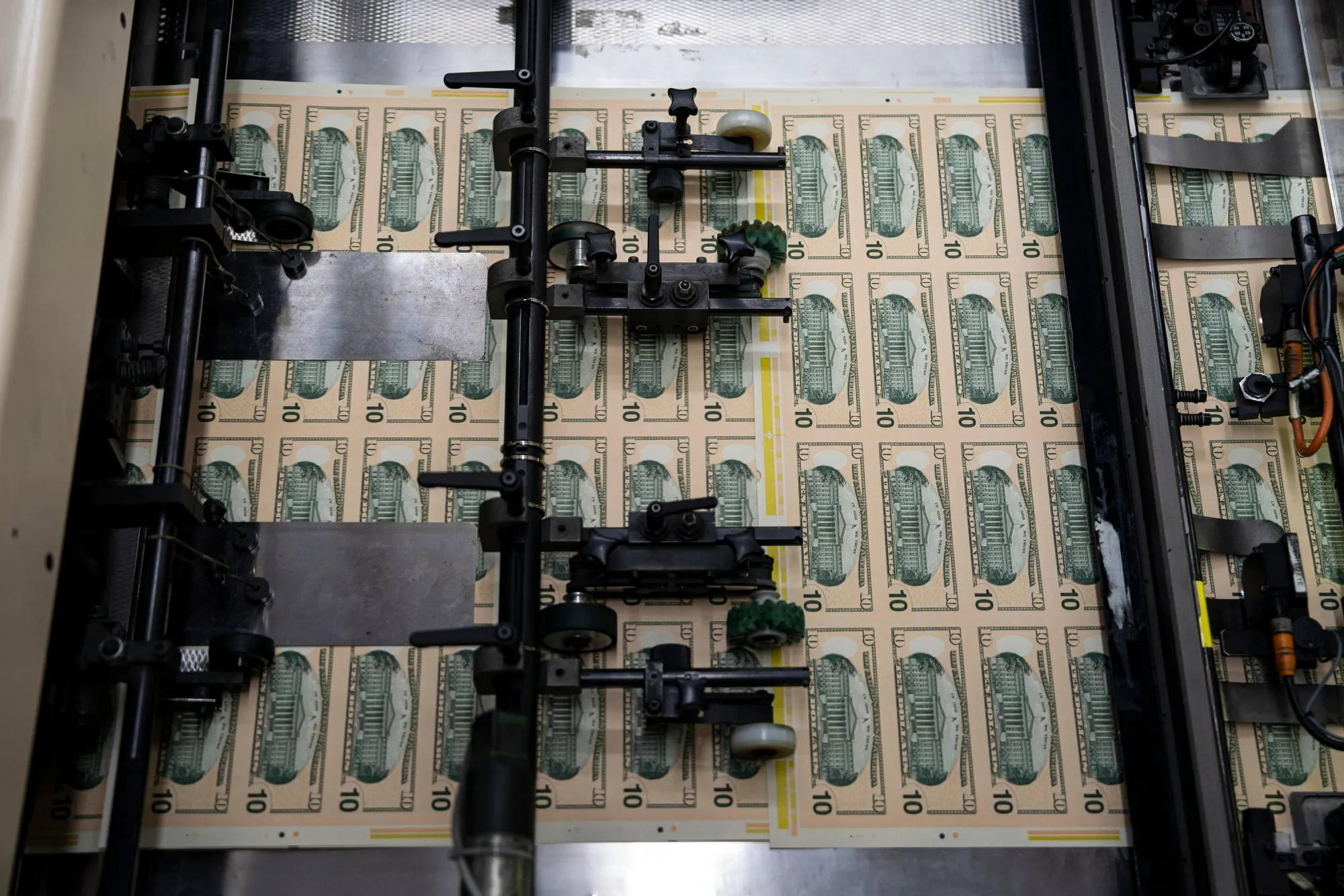 Stacks of $10 dollar notes move through a machine at the US Bureau of Engraving and Printing in Washington, DC, US, on Tuesday, May 21, 2024.