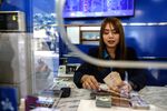 An employee counts 1,000 baht banknotes in a currency exchange store in Bangkok. Photographer: Dario Pignatelli/Bloomberg