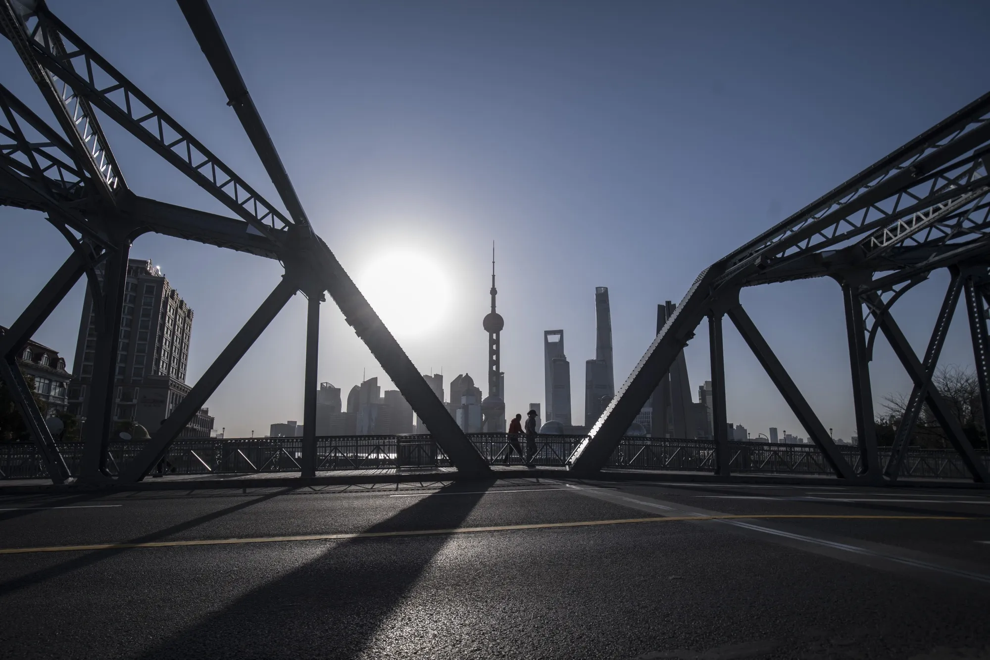 Pedestrians walks across a bridge in Shanghai.