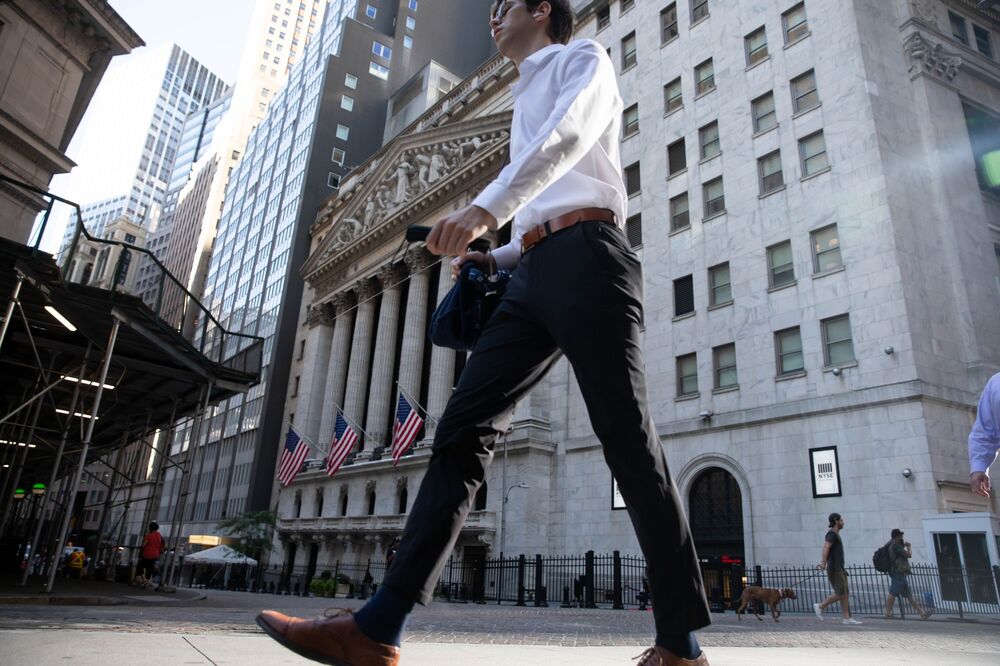 A pedestrian passes in front of the New York Stock Exchange.