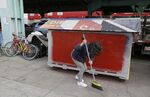 A woman sweeps outside a makeshift homeless shelter in San Francisco.