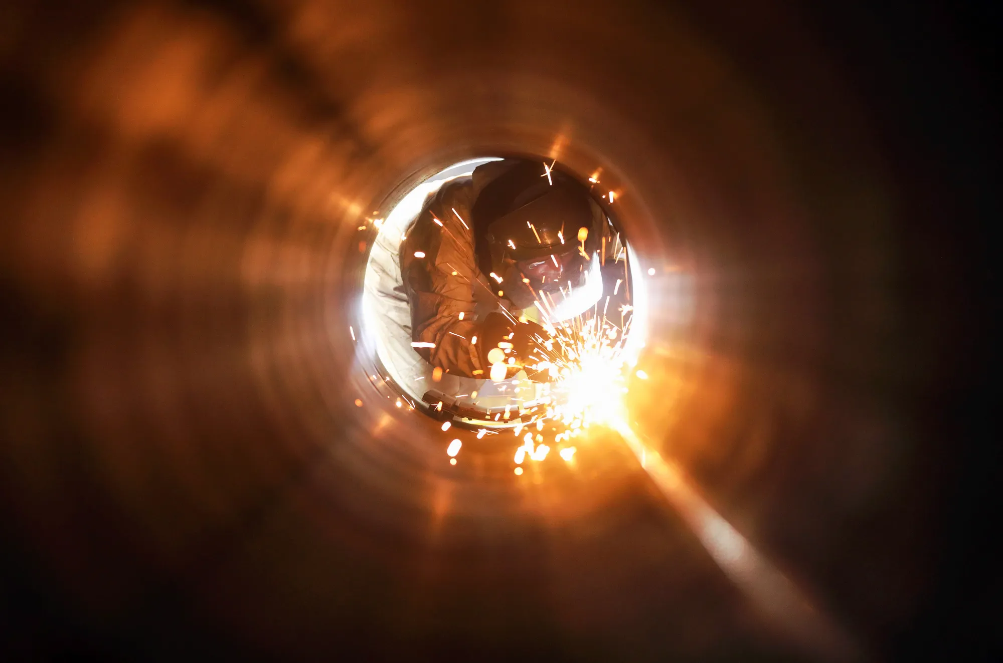 An employee welds the joint inside a steel pipe at a mill in Hartlepool.&nbsp;