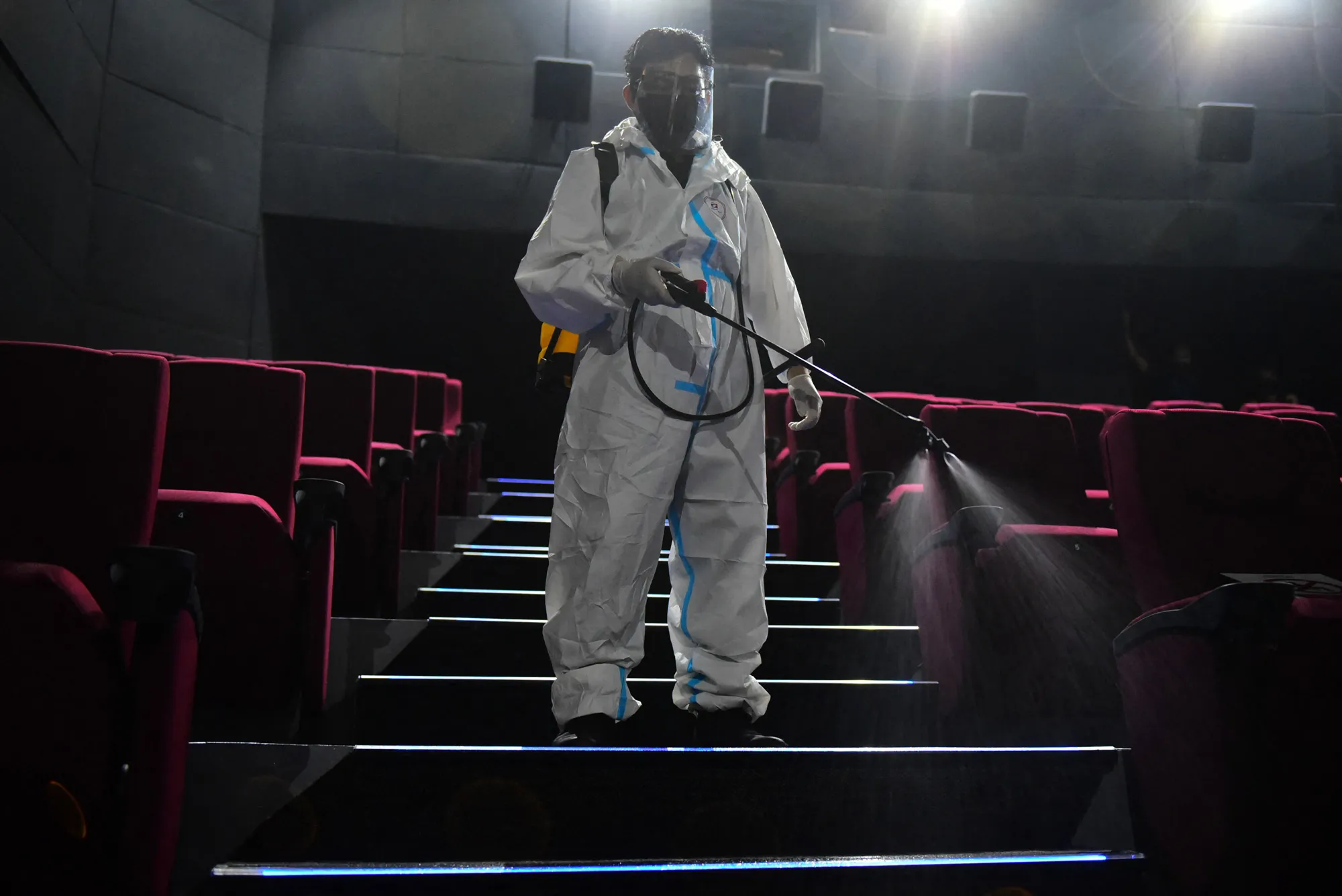 A worker sprays disinfectant inside a cinema in Manila on Oct. 14.