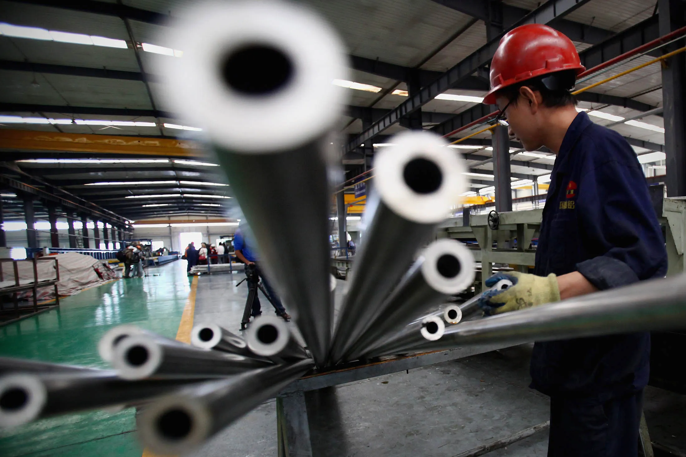 A worker moves the aluminum pipes at the Qinghai Guoxin Aluminium workshop in Qinghai Province.
