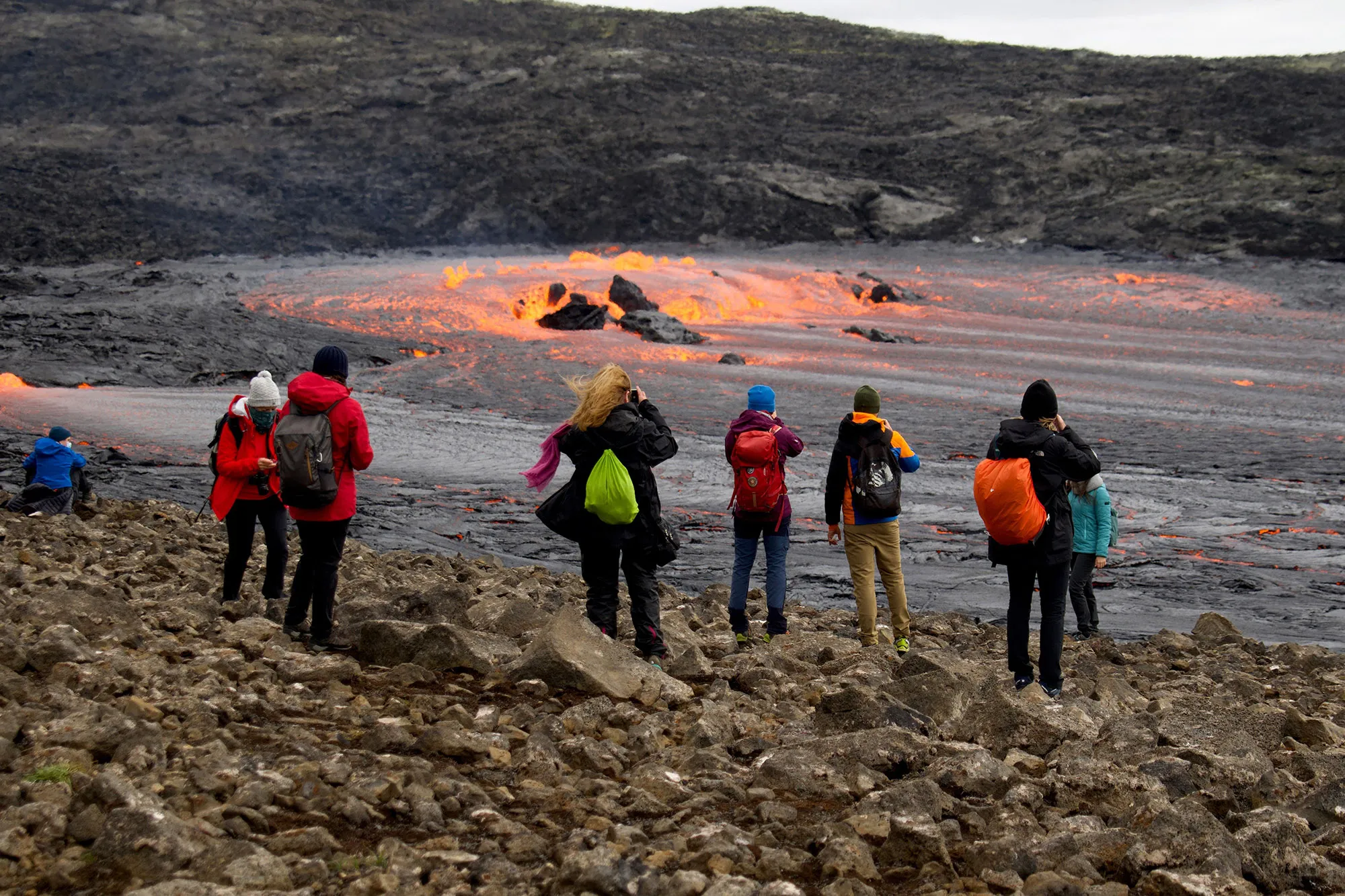 Tourists and visitors watch a lava flow bubbling from a tunnel near the crater in Geldingadalir valley, near Reykjavik on Sept.&nbsp;15.&nbsp;