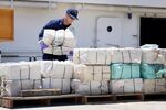 A crew member from a U.S. Coast Guard Cutter piles up some of the 2,200 pounds of cocaine that was seized during Operation Martillo, worth an estimated $27 million, on April 26, 2013, in Miami