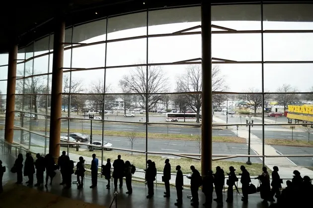 People seeking employment wait in line to enter a job fair on March 28 in Washington