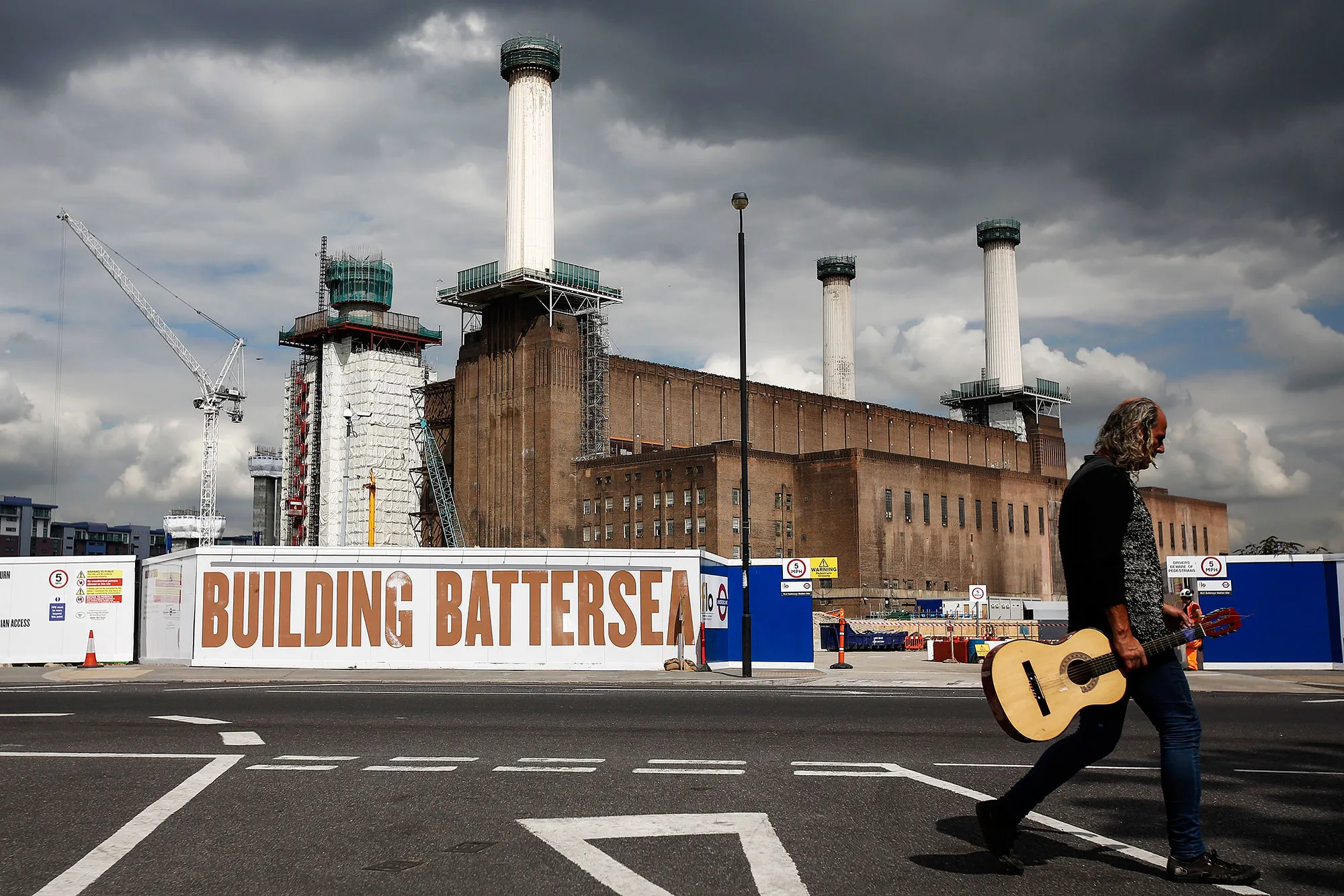 A pedestrian passes the Battersea power station residential and retail development in London, on Aug. 7, 2015.

