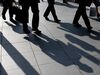 Morning commuters cast shadows on a sidewalk in Tokyo, Japan, on Monday, May 14, 2018. Japan is scheduled to release its first-quarter gross domestic product (GDP) figures on May 16.
