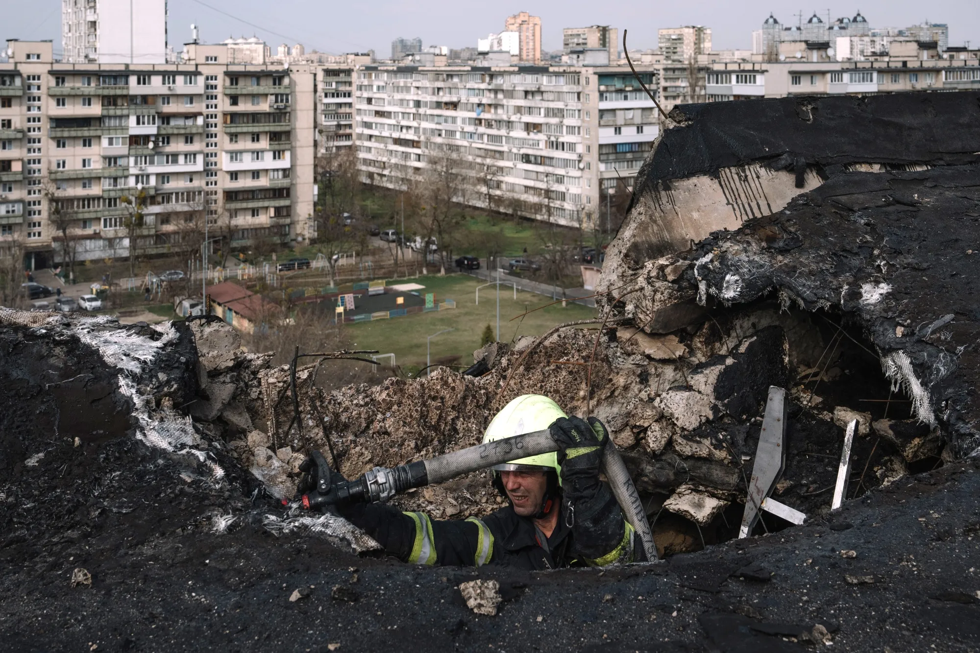 A firefighter at the impact site on a residential building following a Russian night drone strike in Kyiv, Ukraine, on Sunday, March 23, 2025.&nbsp;