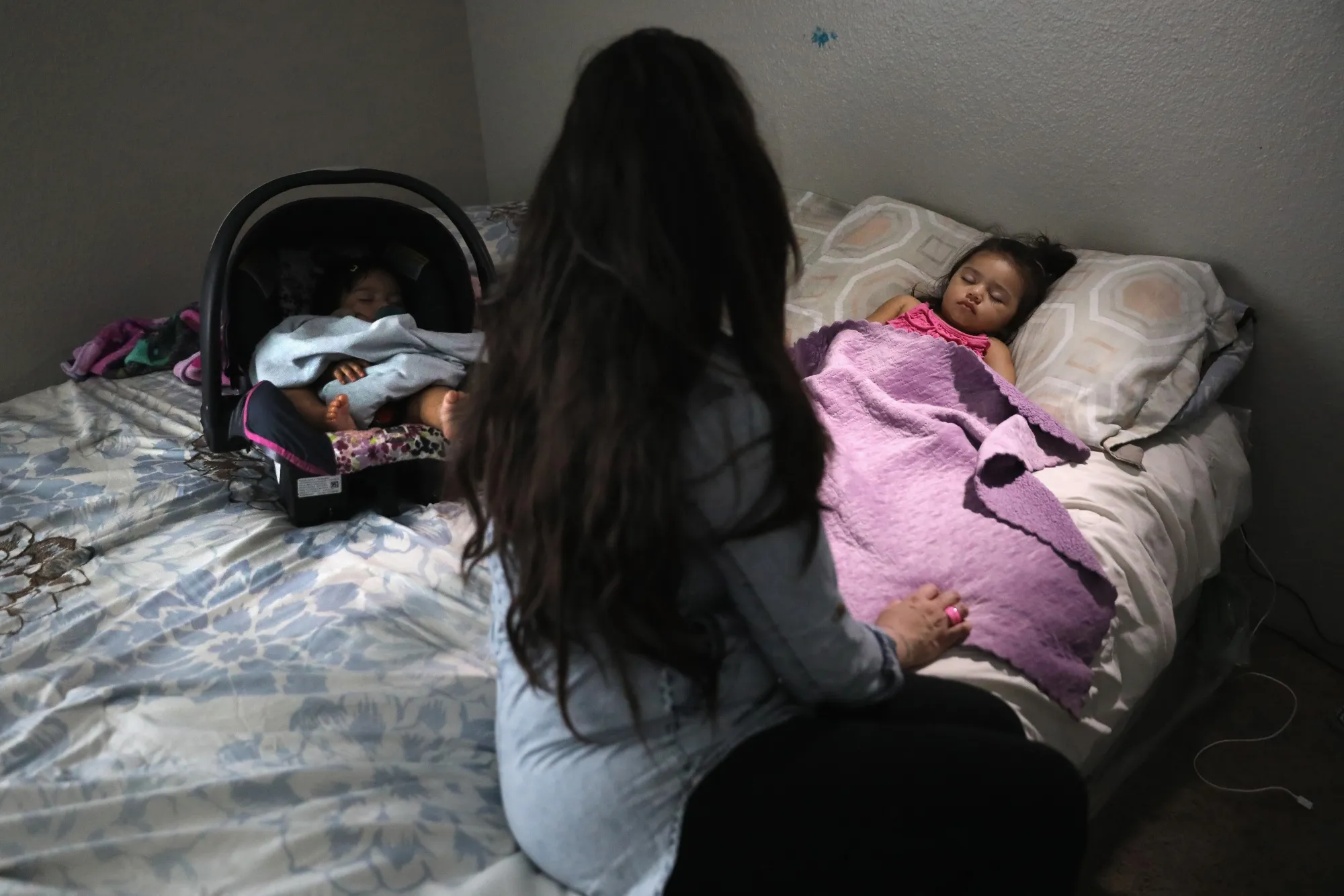 An undocumented immigrant watches over her sleeping children in Denver, Colorado.