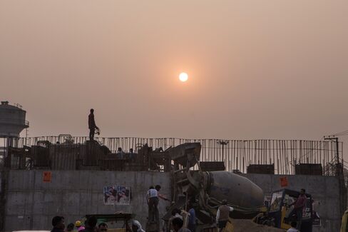 Workers construct a rail bridge in Dadri. Photographer: Prashanth Vishwanathan/Bloomberg