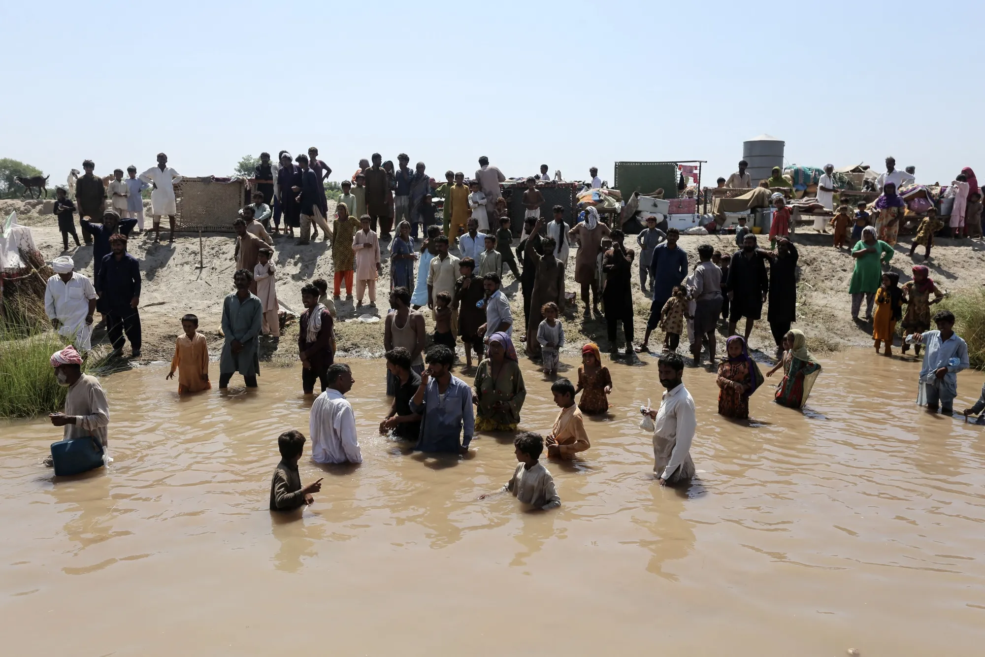 People wait to receive food aid during flooding in Alipur, Muzaffargarh district, Pakistan, on Sept. 13.