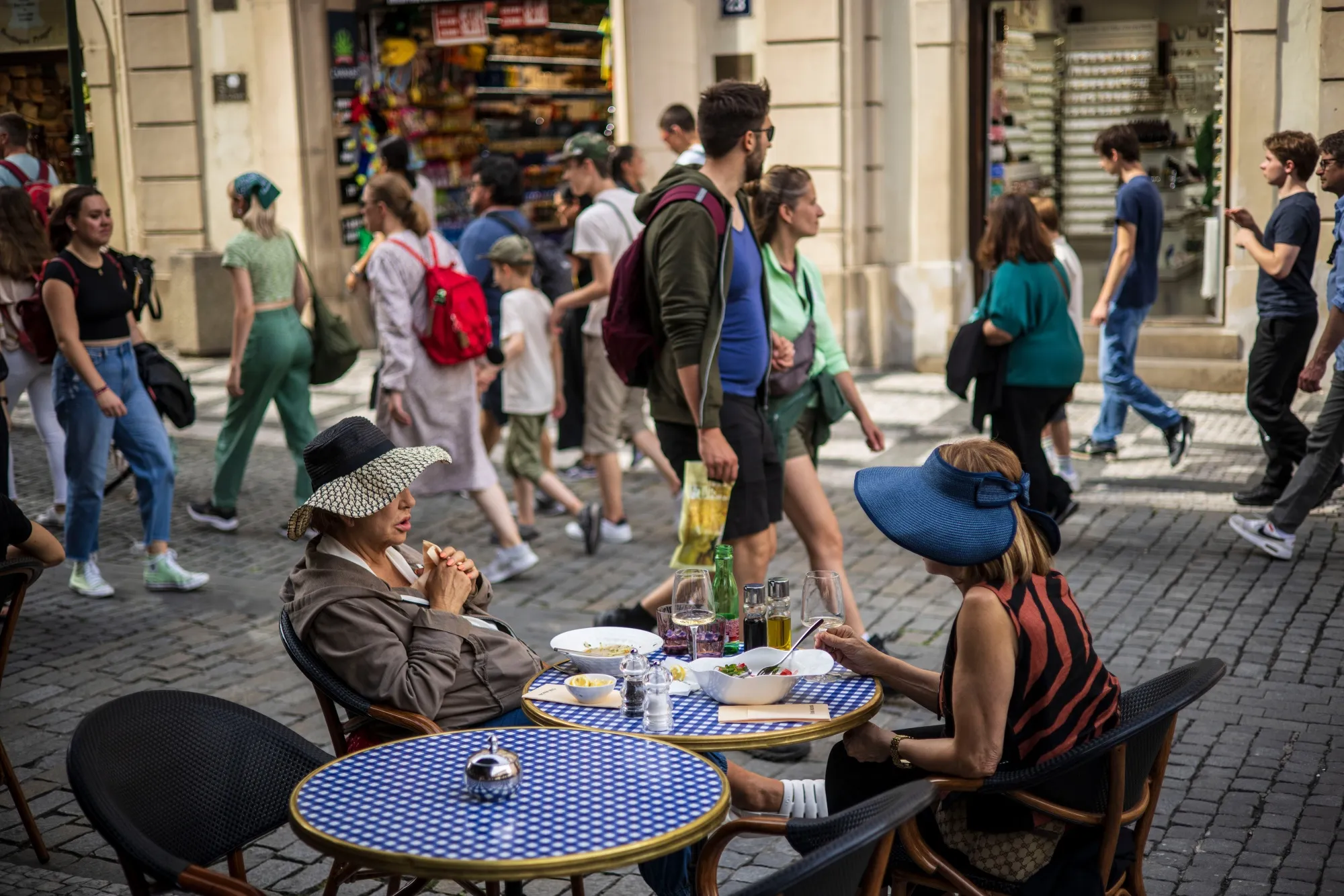 Shoppers pass diners at a cafe on Celetna street in Prague.