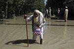 A displaced man wades through a flooded area after fleeing his flood-hit home, on the outskirts of Peshawar, Pakistan, Aug. 28, 2022. The flooding has all the hallmarks of a catastrophe juiced by climate change, but it is too early to formally assign blame to global warming, several scientists tell The Associated Press. (AP Photo/Mohammad Sajjad, File)