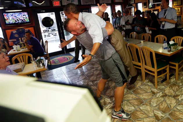President Obama is picked up and lifted off the ground by Scott Van Duzer, owner of Big Apple Pizza and Pasta Italian Restaurant in Fort Pierce, Fla., on Sunday