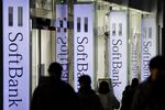 Pedestrians walk past signage for SoftBank Group Corp. outside a store in Tokyo.