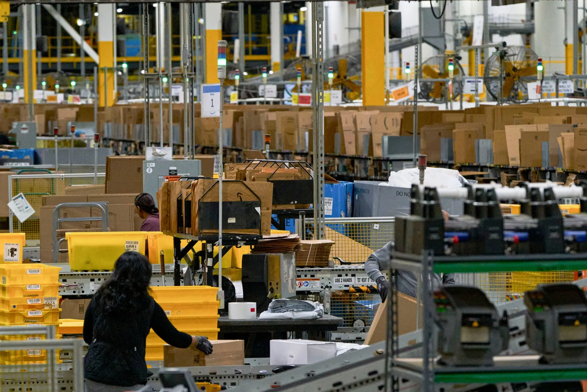Employees work in a packing area at an Amazon fulfillment center.