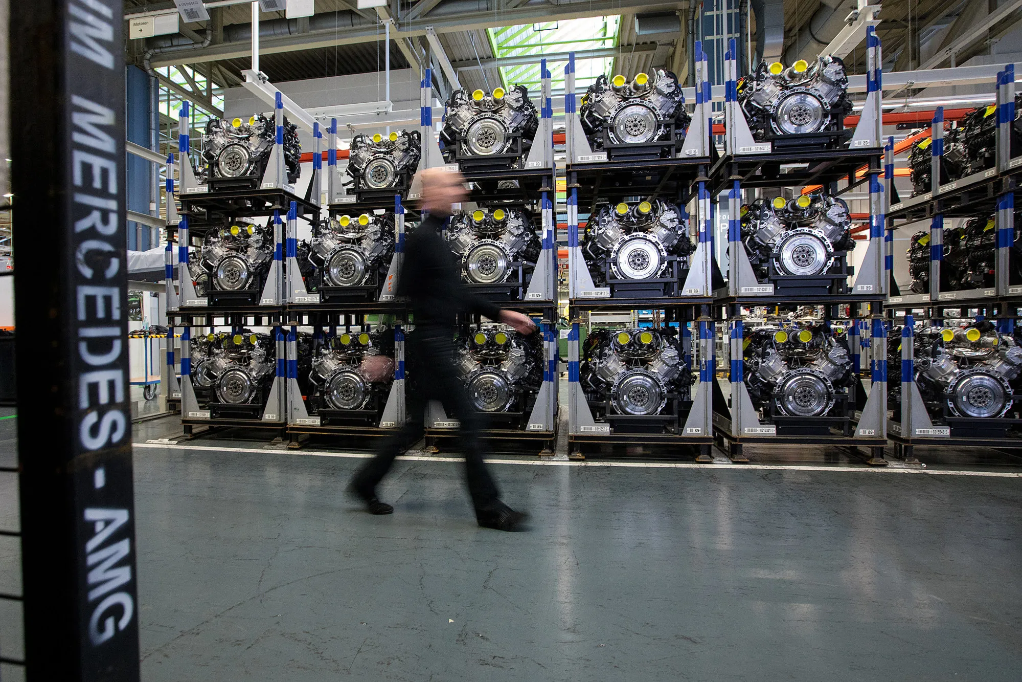 An employee passes&nbsp;engines&nbsp;at a Mercedes-Benz&nbsp;assembly line in Sindelfingen, Germany.