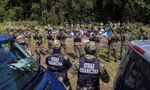 Polish border guards surround migrants in the village of Usnarz Gorny near Bialystok, Poland, close to the border with Belarus, on Aug. 20.
